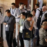 Une foule de personne dans le hall d'un palais des congrès lors d'une pause café