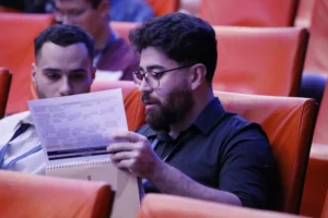 Deux personnes dans un auditorium regardant un programme papier